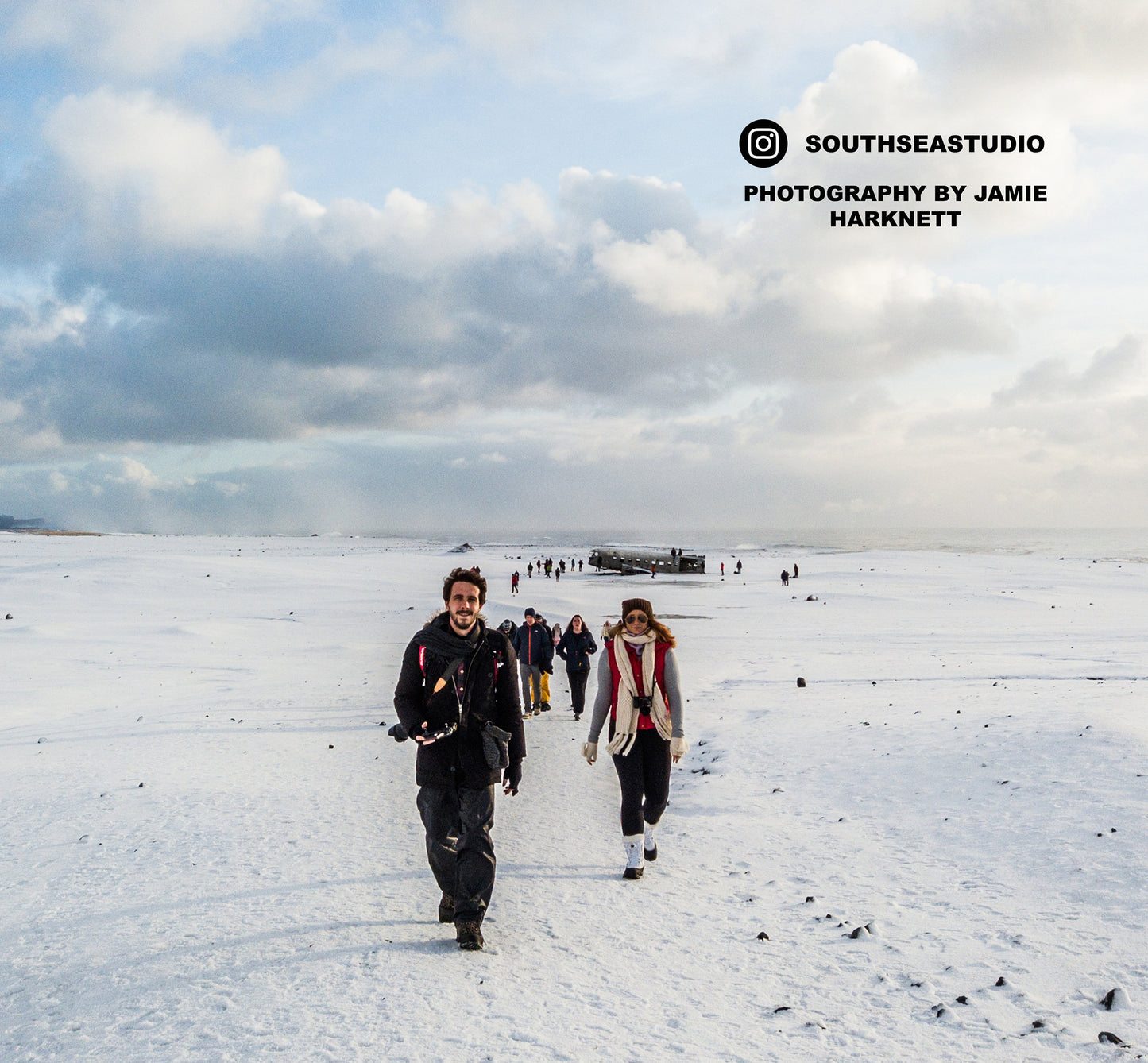 a group of people walking across a snow covered field